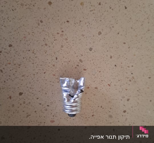בסיס מתכת שבור של נורת חשמל על רקע בהיר